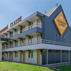 Façade d'un hôtel Première Classe avec escalier extérieur et parking.