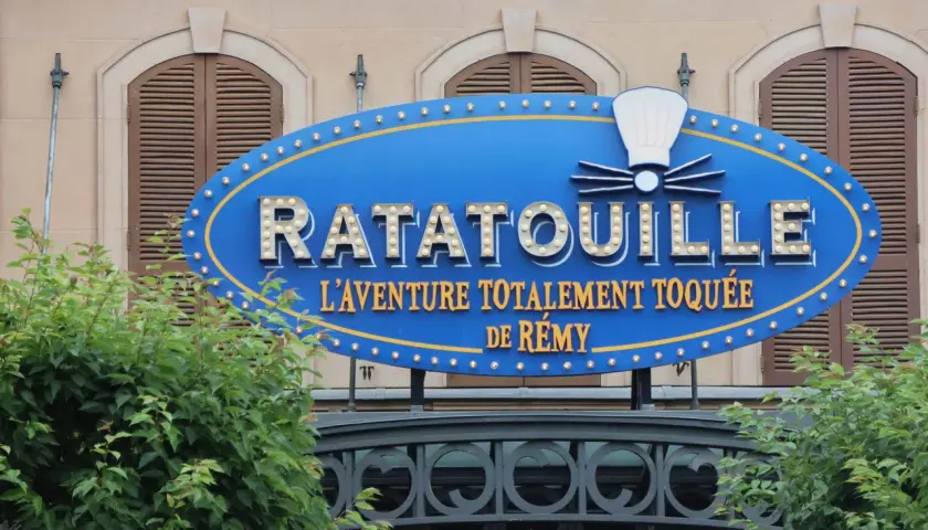 Panneau bleu lumineux de Ratatouille, l'aventure totalement toquée de Rémy, devant un bâtiment.