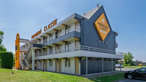 Façade d'un hôtel Première Classe avec escalier extérieur et parking.